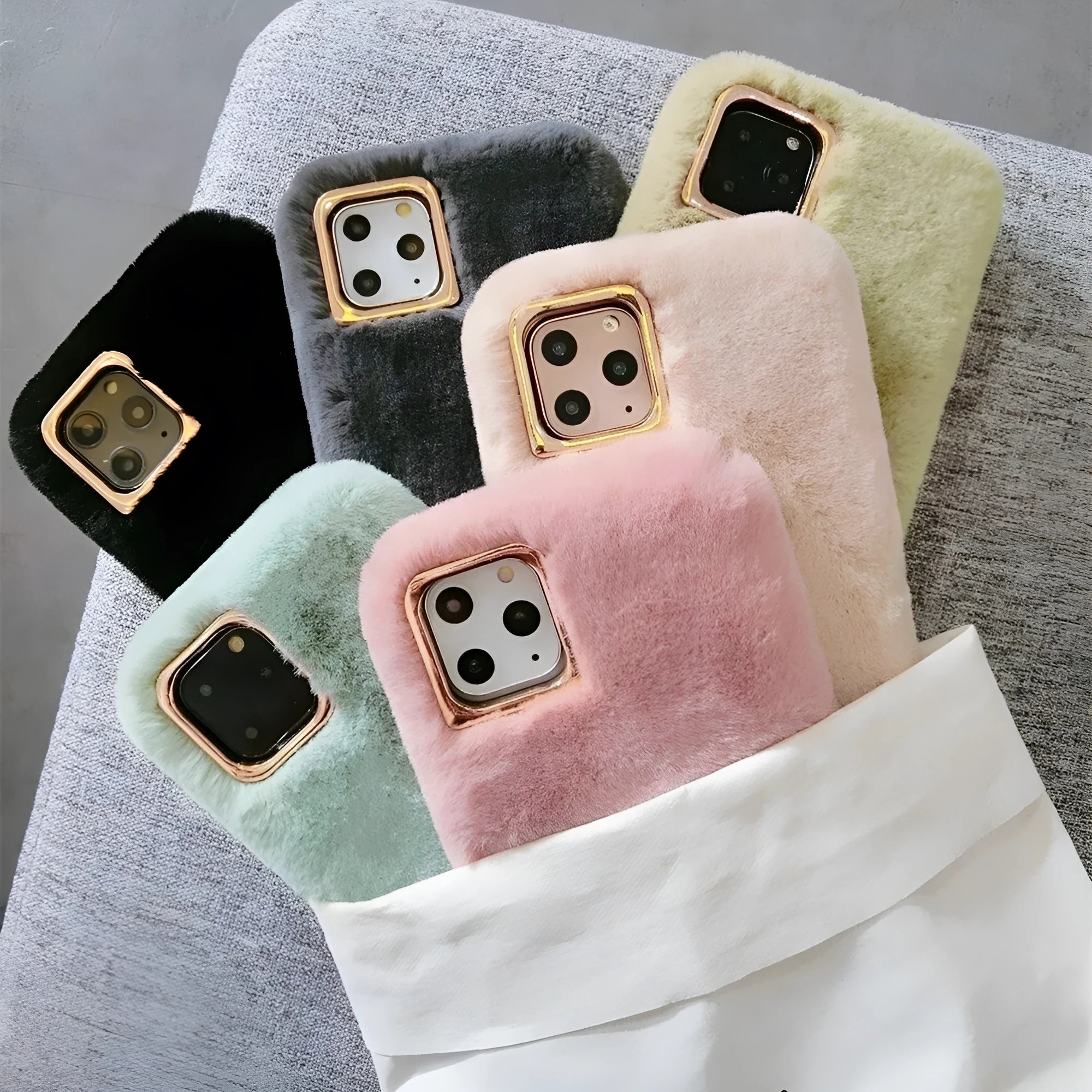 A pink rabbit plush phone case next to a silicone shell, showing the raised camera circle.