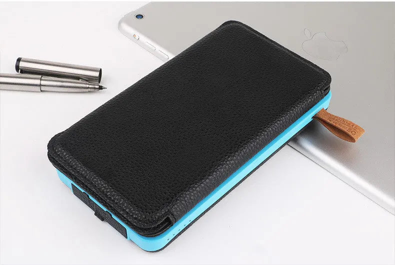 A black outdoor solar power bank with a solar panel, LED light, and soft leather finish, shown with a charging cable.