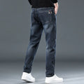 Man wearing slim straight blue grey casual trousers with a zip fly and mid waist.