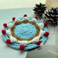 Handmade round wool coaster bag for hot mugs on a table