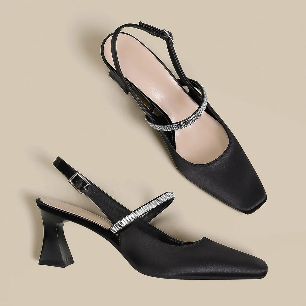 Women's black stiletto high heel sandals with a closed pointed toe and a single buckle strap across the foot.