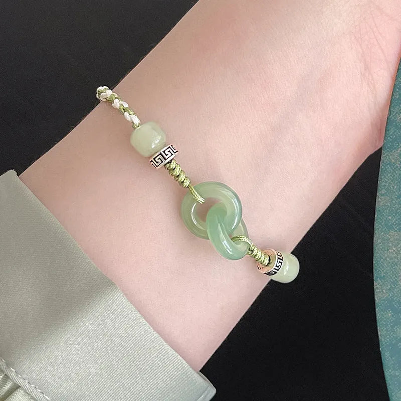Women's copper bracelet with jade peace buckle and ethnic woven double-ring strap.