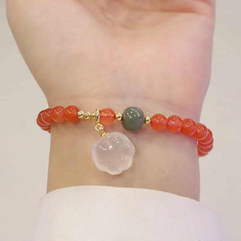 Natural red agate bracelet with jade beads and a Cat's Paw charm, showing 8mm agate beads and gem inlay detail.