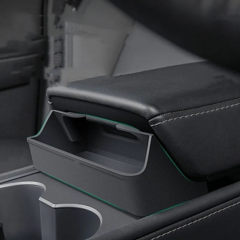 Black silicone sunglasses case mounted in a Tesla Model 3 or Y centre console.