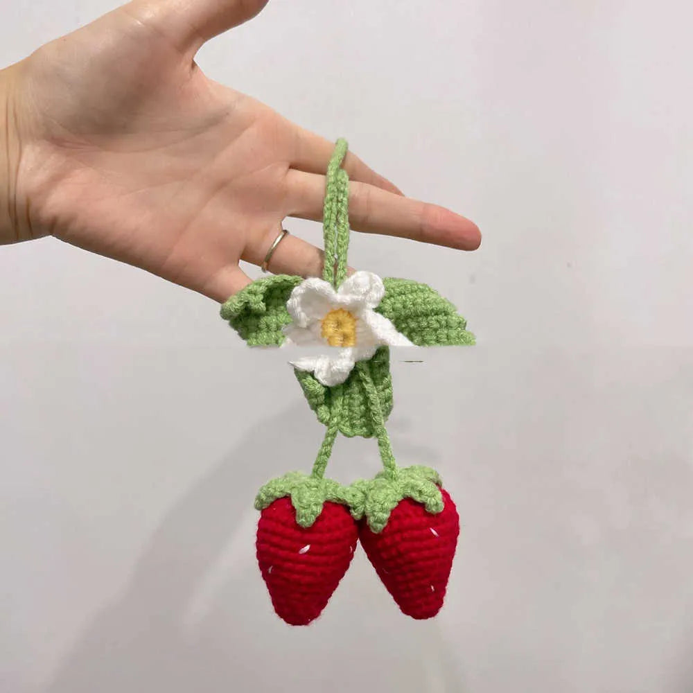 Handmade strawberry-shaped car pendant woven from cotton and hemp wool, hanging as a decorative accessory.