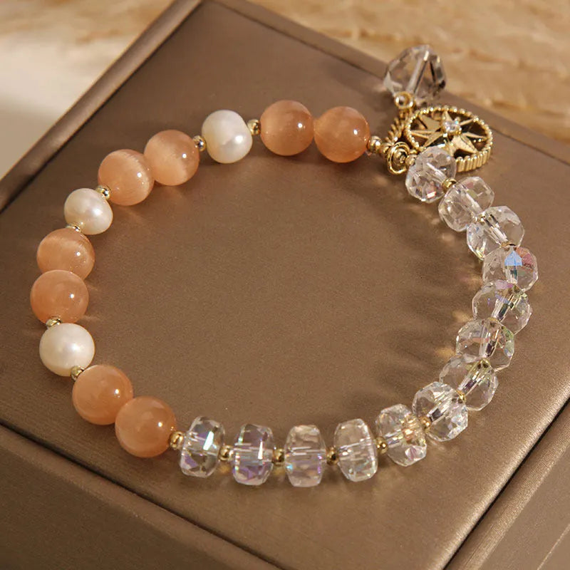 Women's gold-plated bracelet with an eight-pointed star design and a central inlaid orange opal crystal.