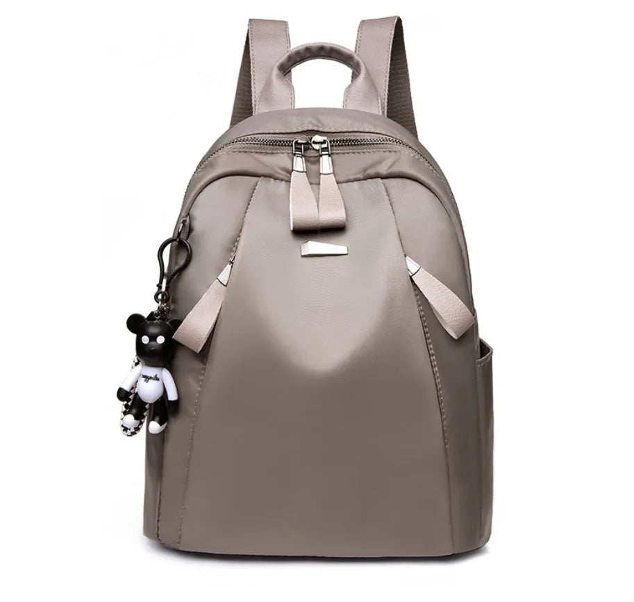 Medium square-shaped wine red Oxford cloth rucksack with double black straps and a soft handle.