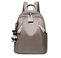 Medium square-shaped wine red Oxford cloth rucksack with double black straps and a soft handle.