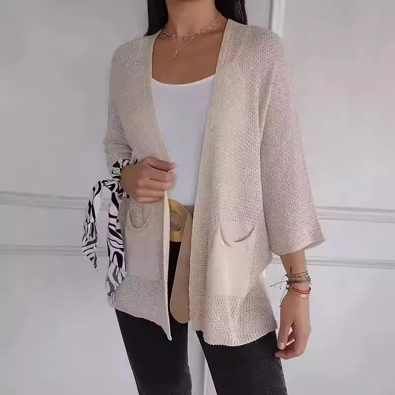 Women's longline waffle-textured cardigan coat in army green, showing pocket detail and nine-quarter sleeve length.