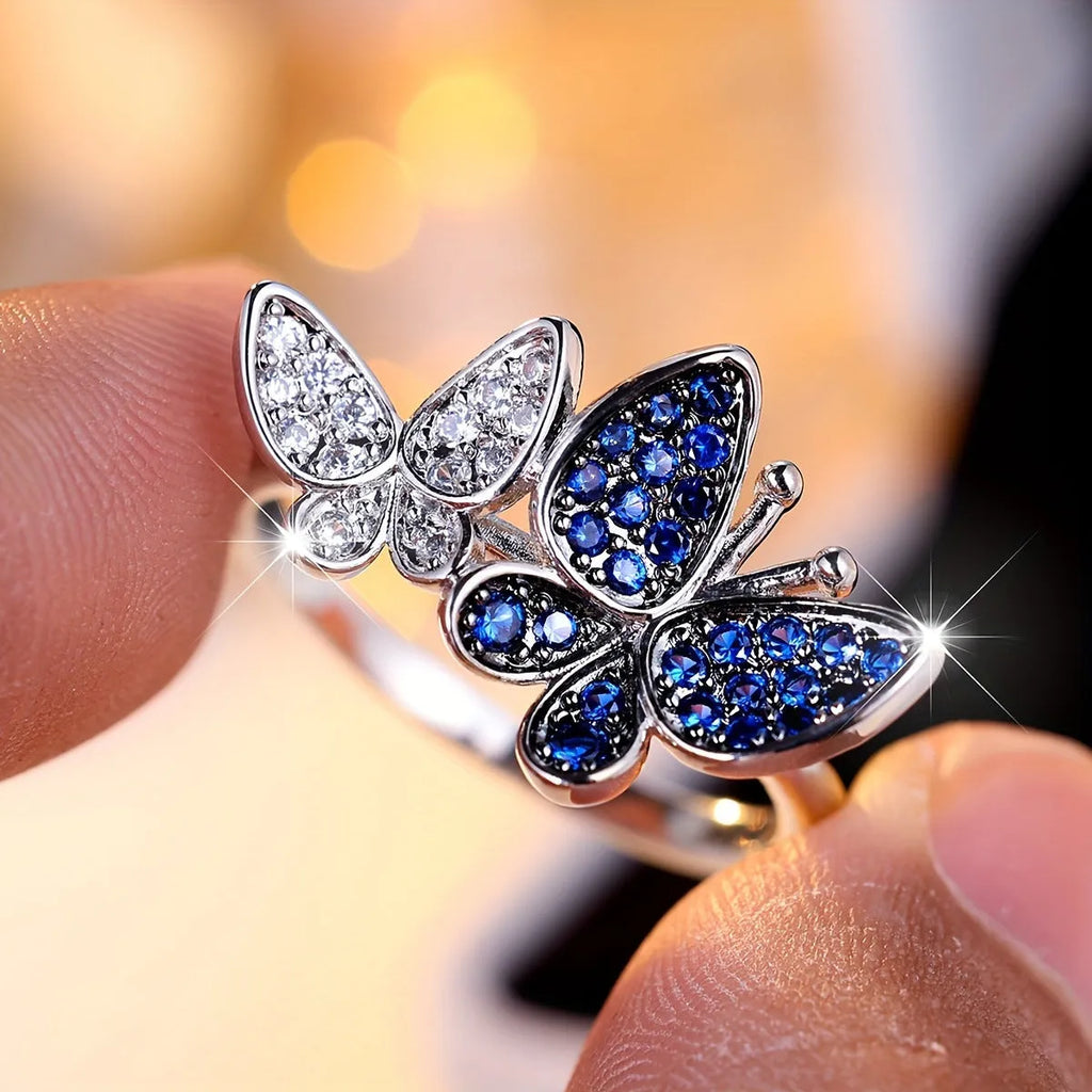 A blue and white electroplated butterfly ring for women, made from copper, shown in UK size 10.