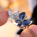 A blue and white electroplated butterfly ring for women, made from copper, shown in UK size 10.
