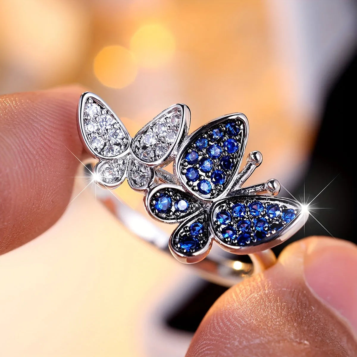 A blue and white electroplated butterfly ring for women, made from copper, shown in UK size 10.