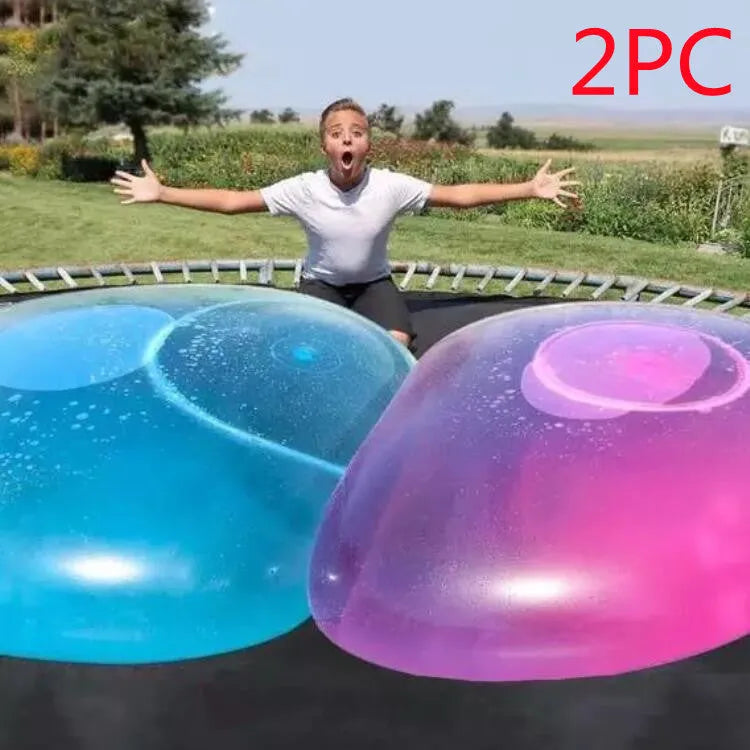 Large pink inflatable bubble ball on grass, showing its size and smooth TPR surface.