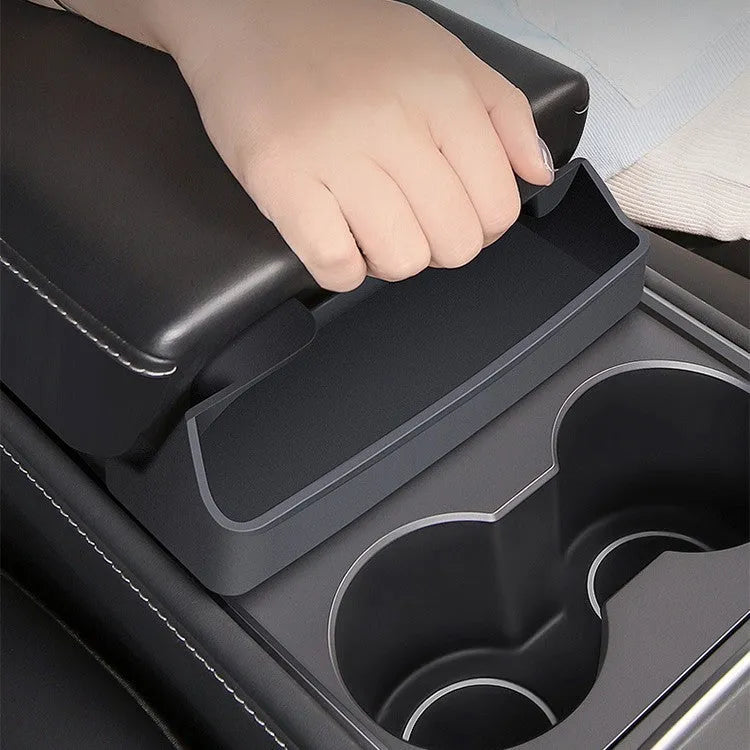 Black silicone sunglasses case mounted in a Tesla Model 3 or Y centre console.