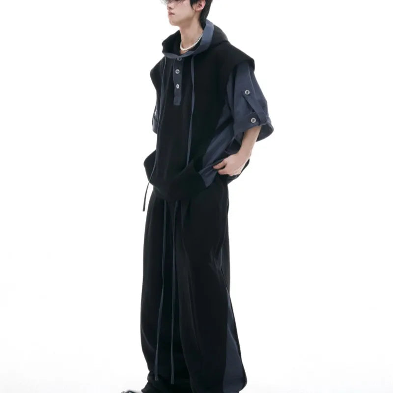 Man wearing a black hooded short-sleeve leisure jacket with textured stitching and matching trousers.