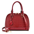 Shiny black shell-shaped crossbody bag showing front view and shoulder strap.