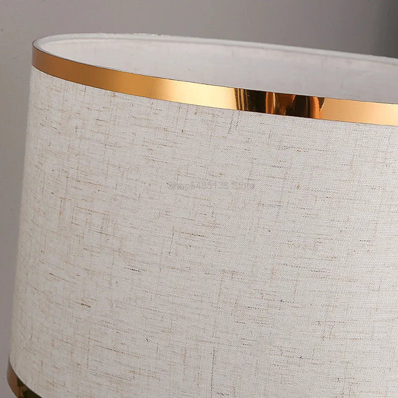 Iron table lamp with cloth shade in black, gold, or white colour on a wooden table