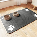 Diatomaceous earth pet feeding mat in grey colour under a dog water bowl on a wooden floor.
