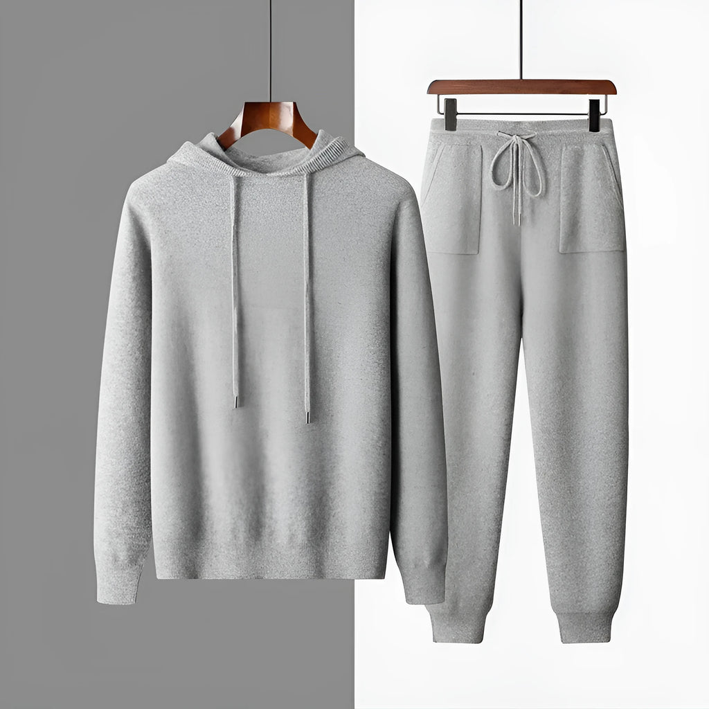 Man wearing a light grey hooded cashmere sweatshirt and matching casual trousers.