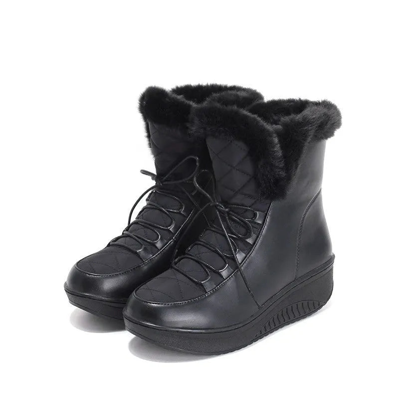 Women's black lace-up ankle boots with a platform sole on a wooden floor.