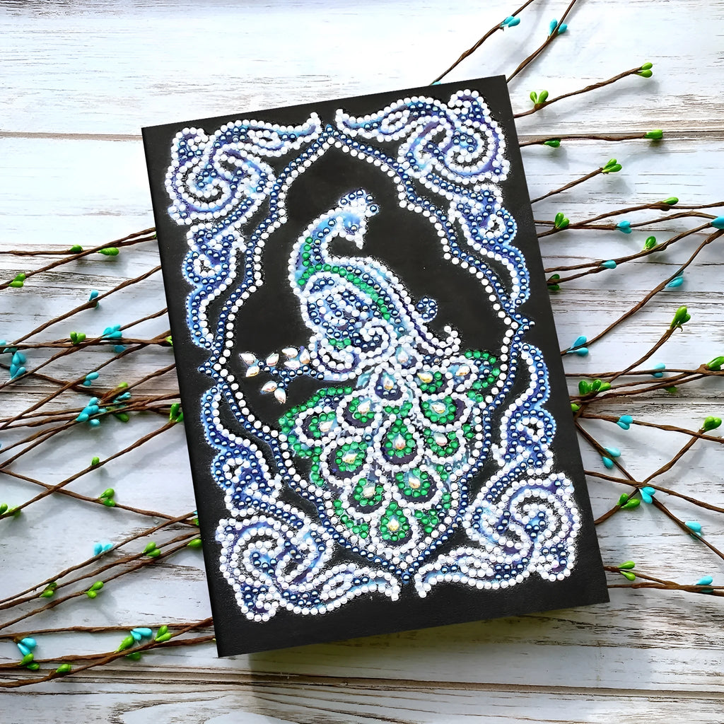 A5 black diamond painting notebook open to show peacock artwork with shaped and bright drills.