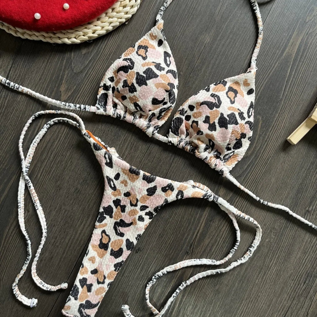 Women's printed bikini swimsuit on a hanger, showing briefs style and cotton lining detail.