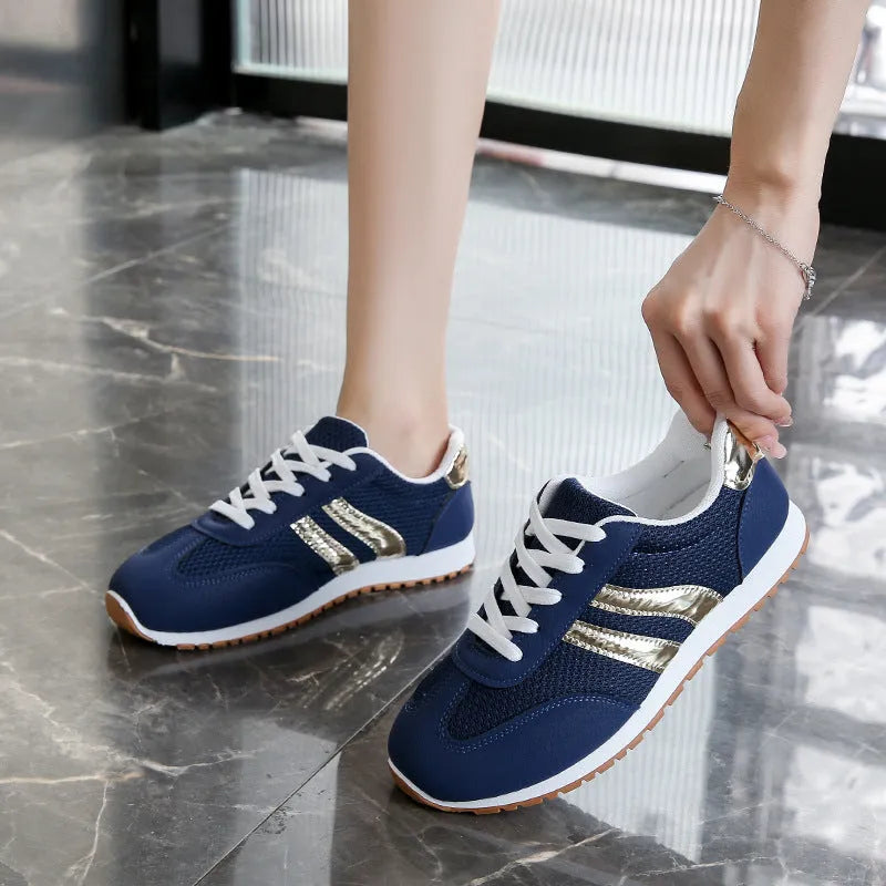 Blue women's casual tennis shoes with cross shoulder straps and a lace-up front on a rubber sole.