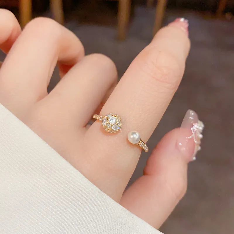 Open-end ring with round zircon stones and pearl accents in gold or silver plating