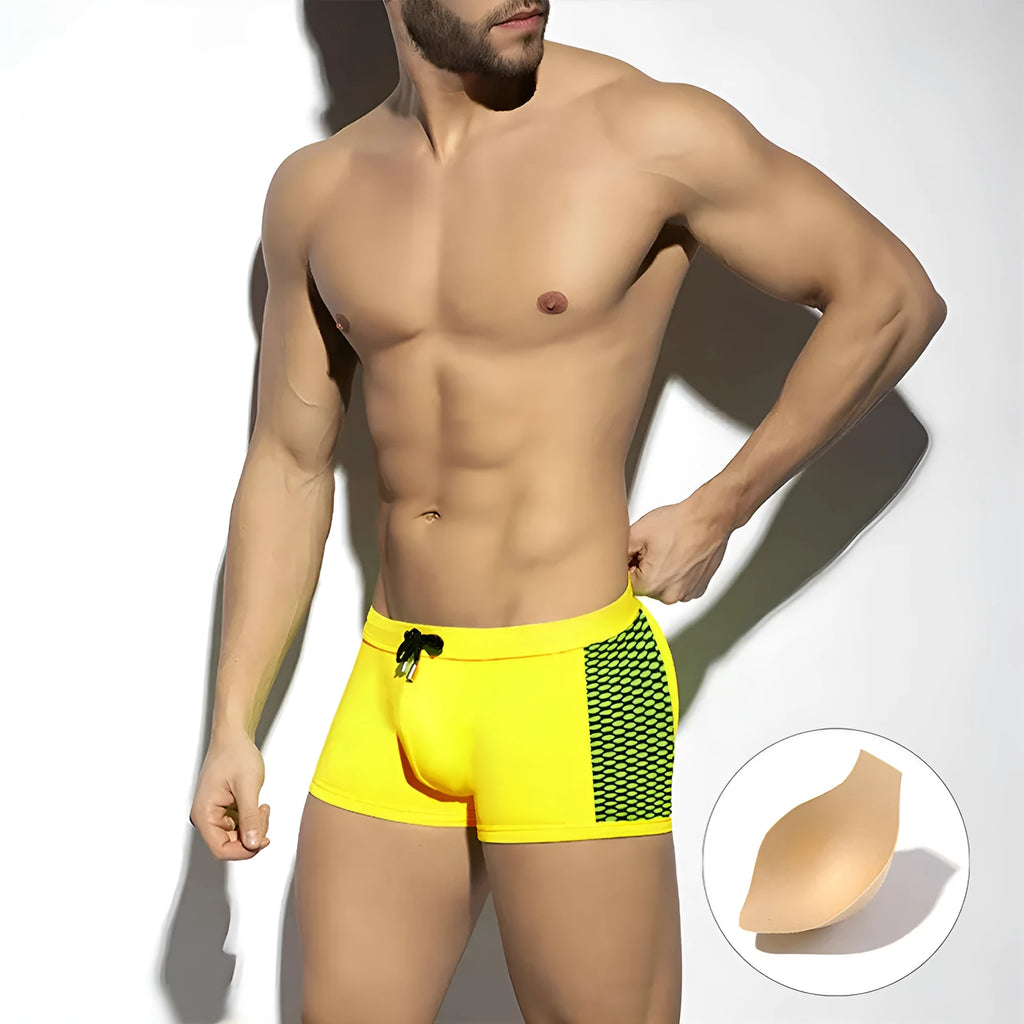 Yellow polka dot print men's swimming boxers on a mannequin, showing brief style.