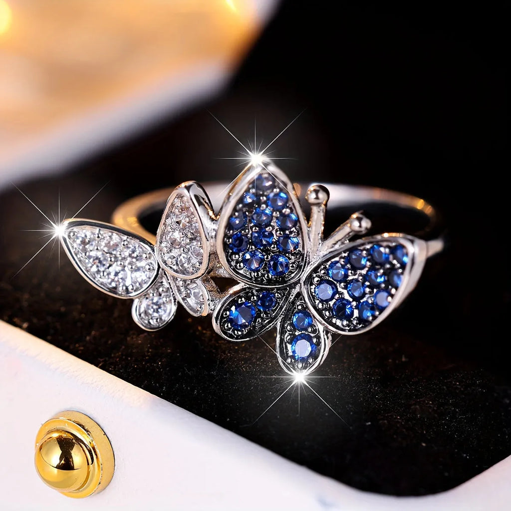 A blue and white electroplated butterfly ring for women, made from copper, shown in UK size 10.