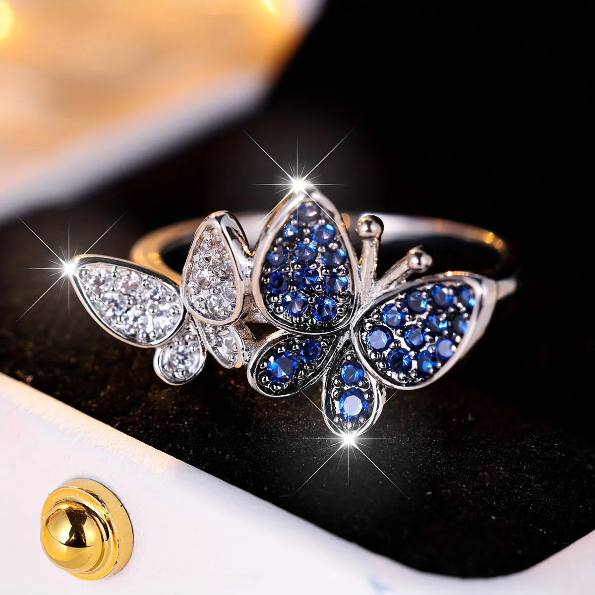 A blue and white electroplated butterfly ring for women, made from copper, shown in UK size 10.