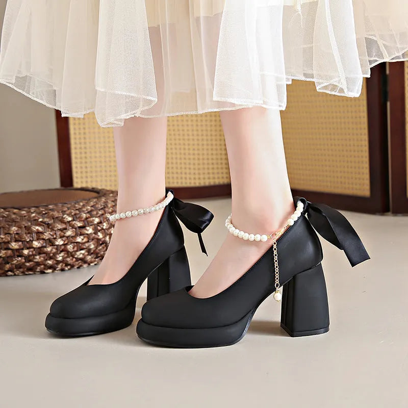 Women's beige Mary Jane shoes with a chunky heel and an adjustable ankle strap buckle.