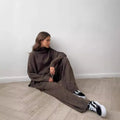 Women's knitted two-piece suit with side-slit sleeve jumper and trousers in dark grey.
