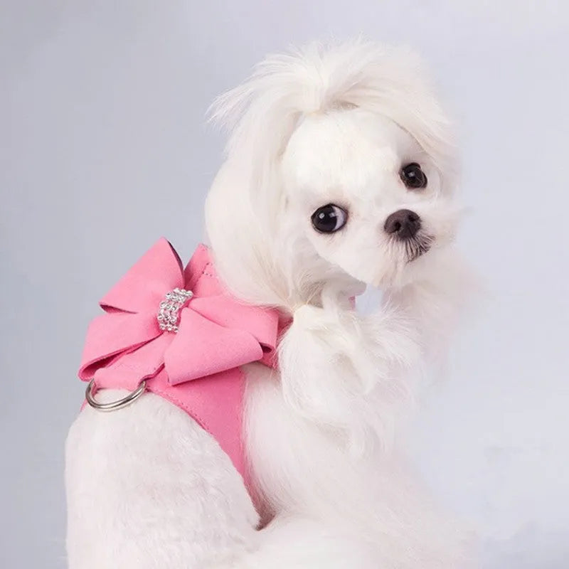 Close-up of a pink microfiber dog chest strap with a white bowknot and an adjustable metal buckle.