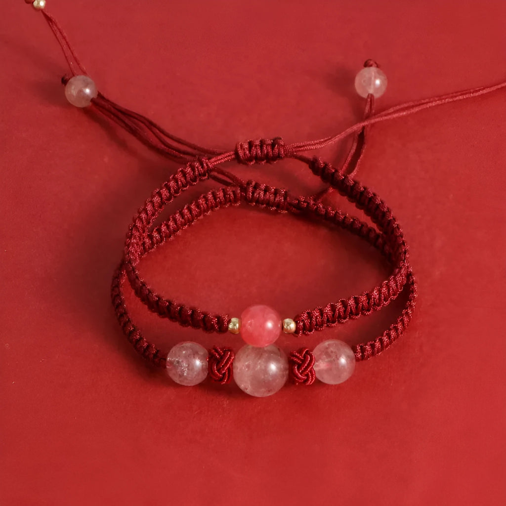 Woven red rope bracelet with spherical strawberry quartz or obsidian beads and an alloy clasp.