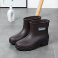 Women's black mid-calf rain boot made of PVC with a low heel.