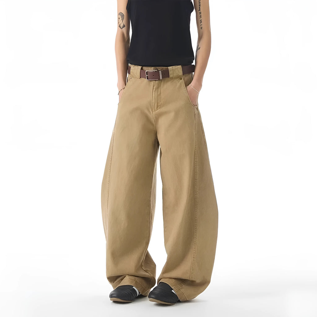 Brown loose fit straight leg men's jeans on a neutral background, showing button fly detail.