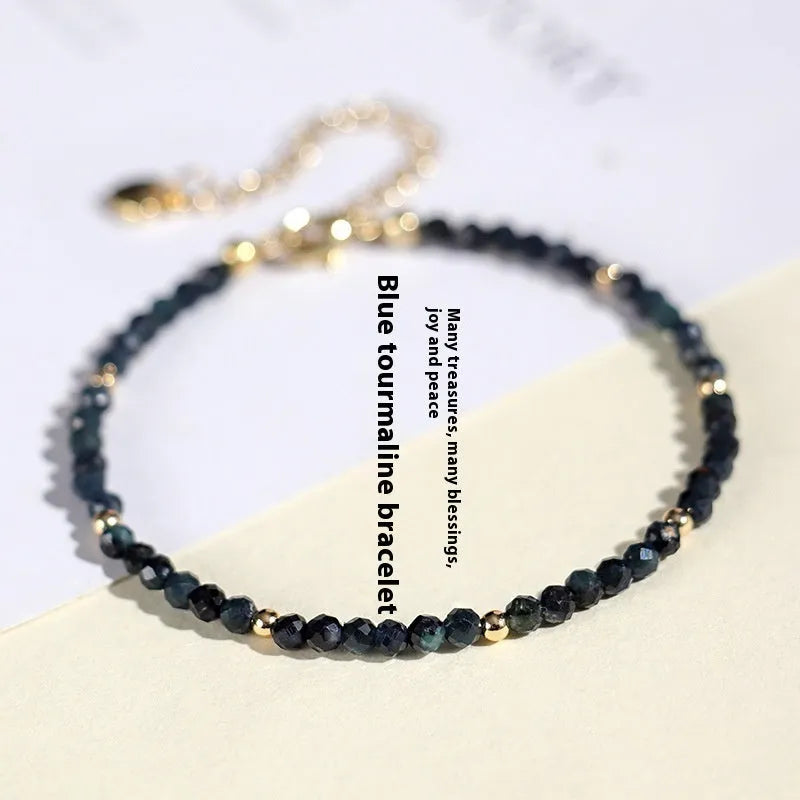 Blue tourmaline bracelet with 3mm beads and metal spacer sections on wrist