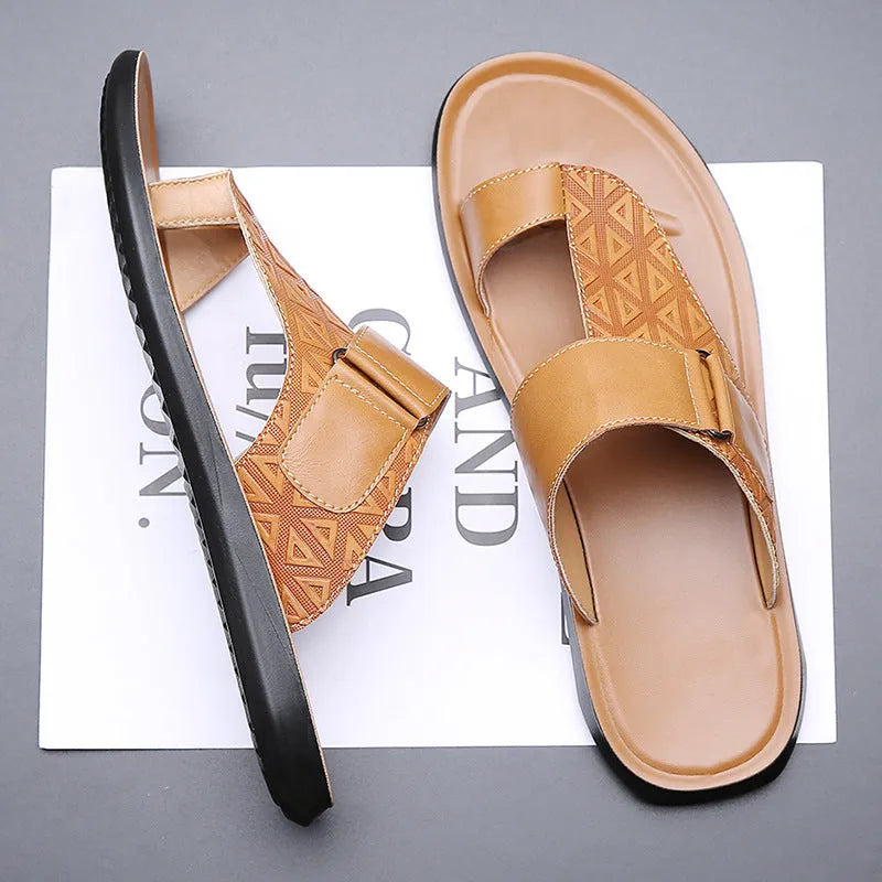 Men's white cowhide open-toe beach slippers with a rubber sole on a sandy background.