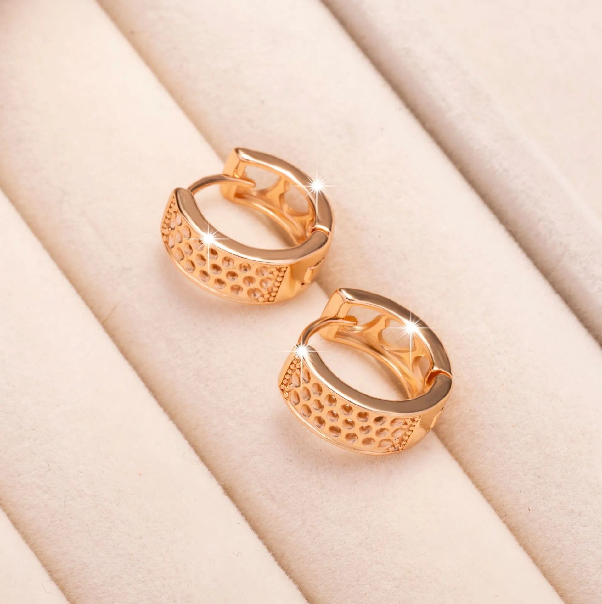 A pair of circular rose gold women's earrings with a three-heart hollowed-out design.