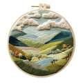 Embroidery DIY kit with cotton fabric, bamboo frame, scissors, and printed landscape pattern