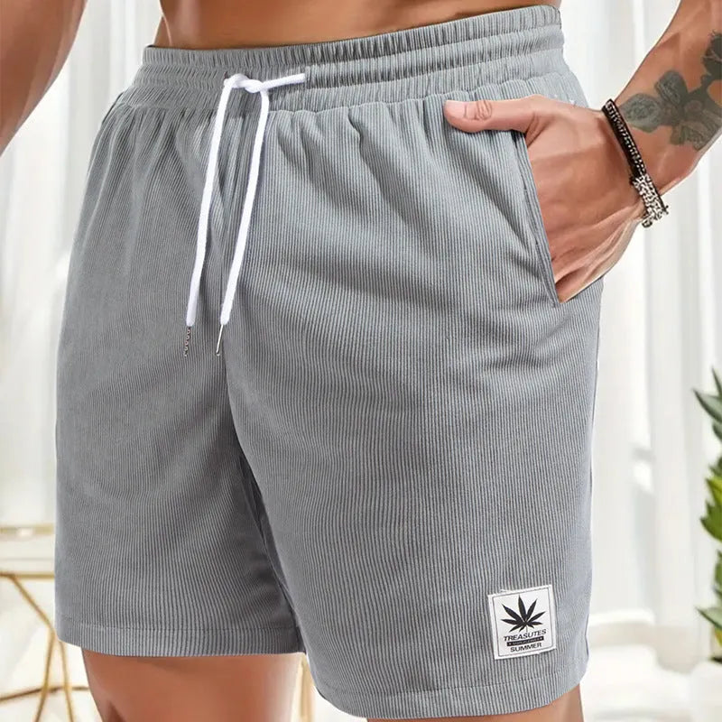 Man wearing grey straight leg drawstring summer shorts made from elastic fabric.