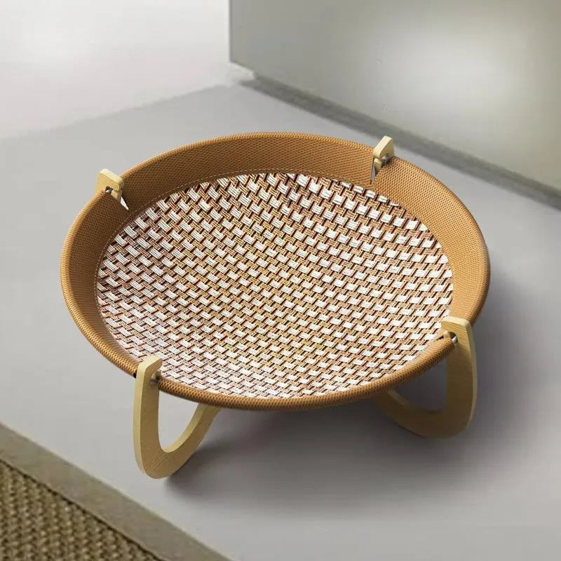 Brown woven rattan elevated hammock bed for cats and small dogs on a wooden floor.
