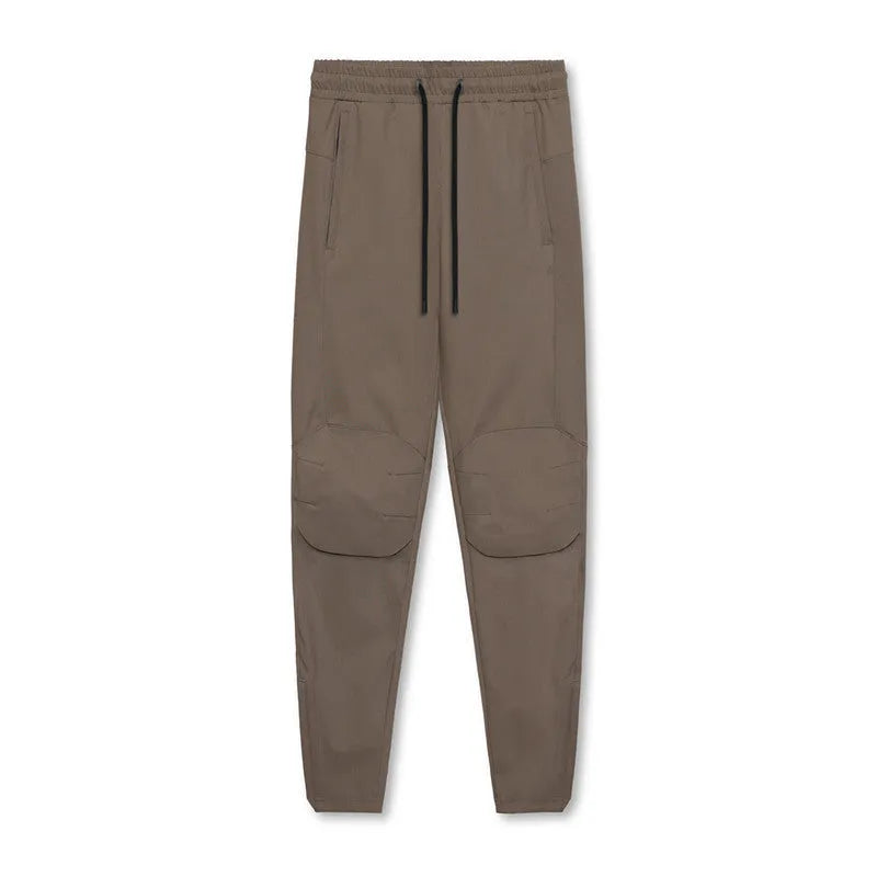 Man in loose grey fitness trousers with tied ankle cuffs, suitable for exercise.