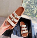 Women's white patent leather Roman sandal slippers with sheepskin lining, shown from the side.