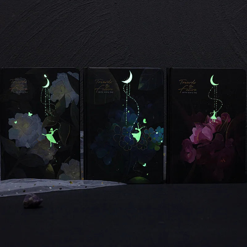 A5 notebook with a luminous blue cover, open to show white paper and a colour illustration page.