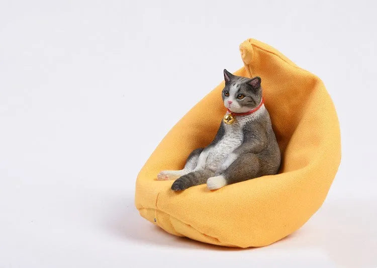 Lazy cat and sofa miniature car dashboard ornament made from resin, approximately 7.5cm high.