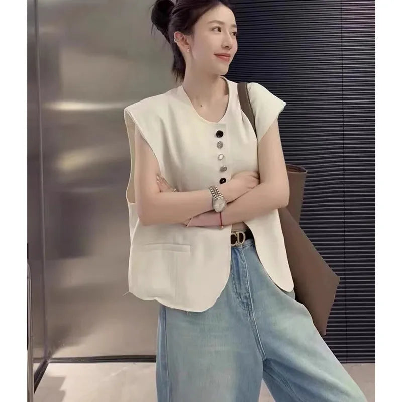 Women's loose fit polyester vest in milky white with a pocket detail and short 40cm length.