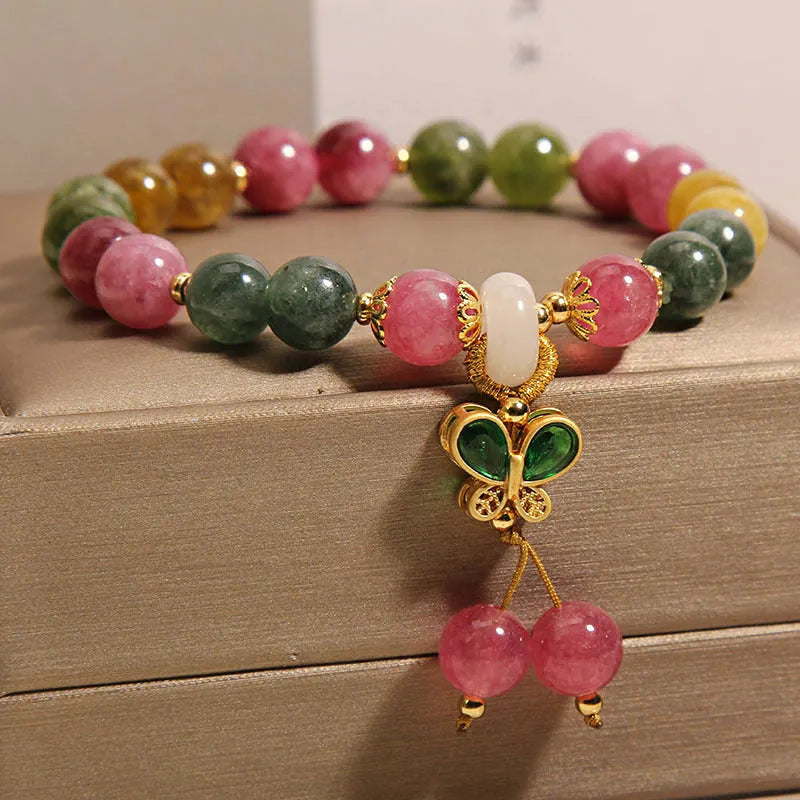 Women's bracelet with natural jade colour tourmaline butterfly pendant and rhinestone accents on alloy setting.