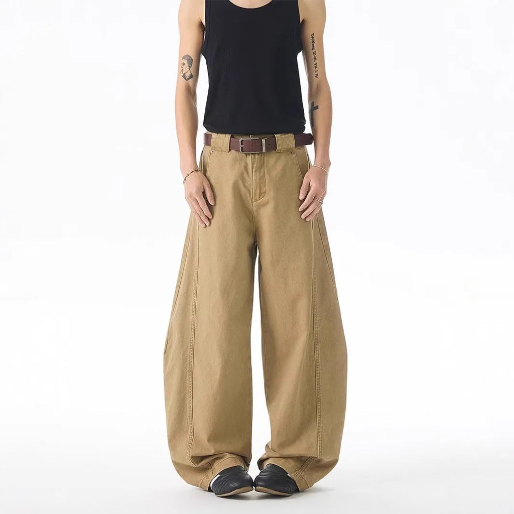 Brown loose fit straight leg men's jeans on a neutral background, showing button fly detail.